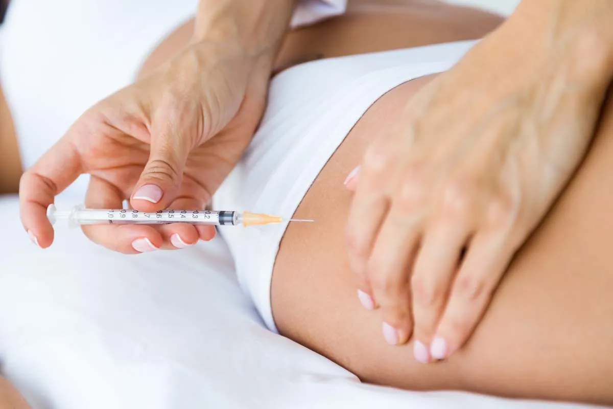 Sesión de carboxiterapia abdominal Mujer aplicándose inyección de carboxiterapia en el abdomen para tratamiento estético