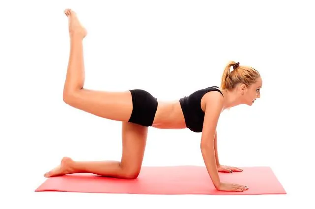 Ejercicio para glúteos firmes Mujer realizando ejercicio de patada para tonificar y elevar glúteos