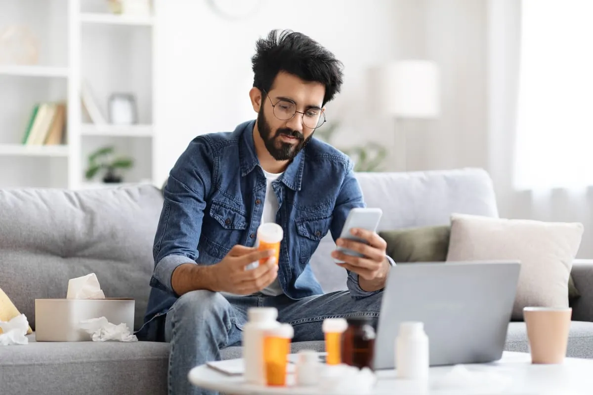 Hombre consultando pastillas para eliminar ginecomastia en el móvil