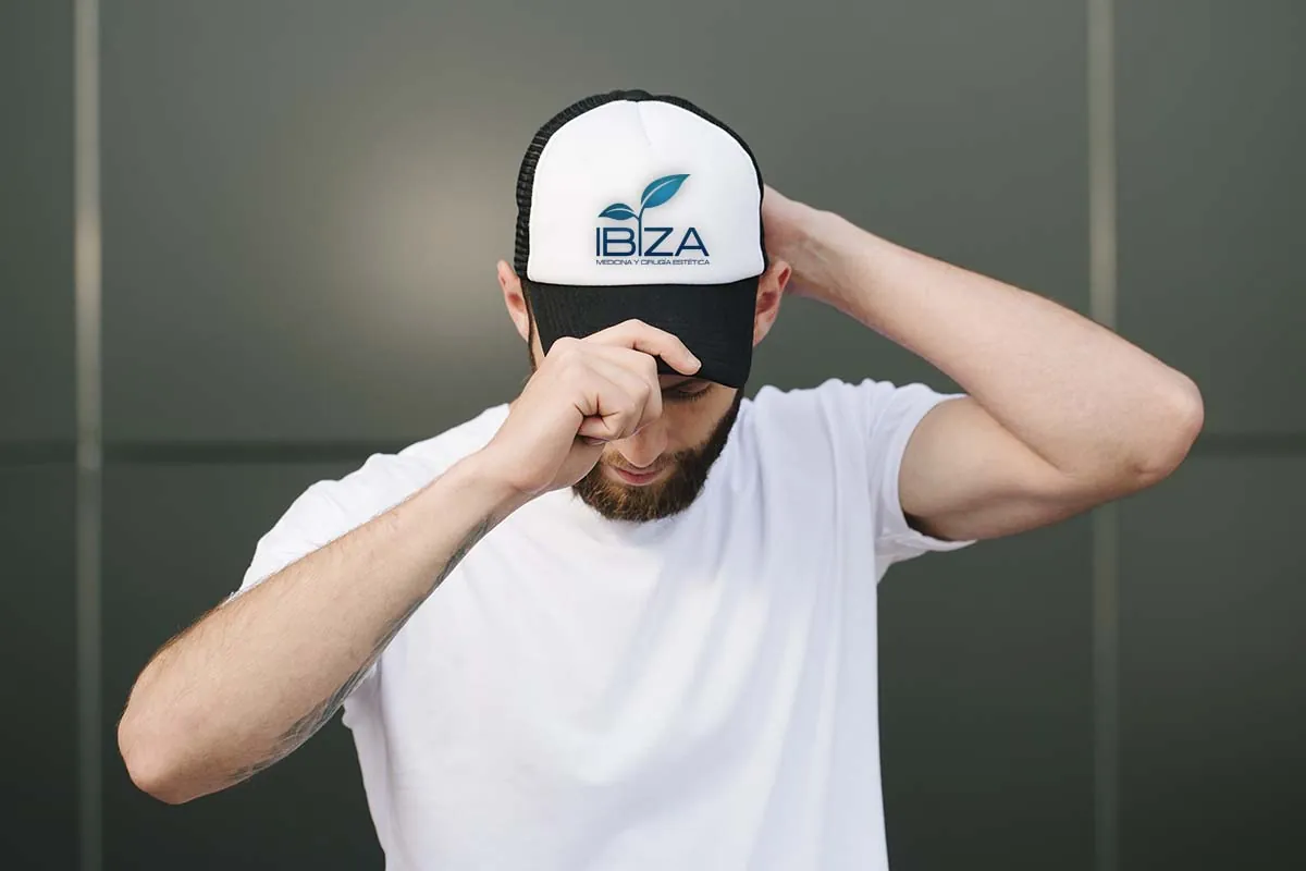 Hombre con barba ajustando gorra después de injerto capilar correctamente