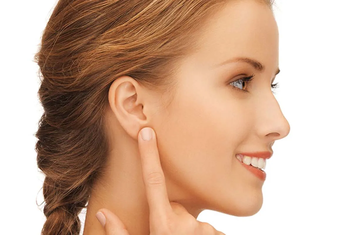Lobuloplastia de lóbulo Mujer señalando lóbulo de oreja antes de lobuloplastia estética